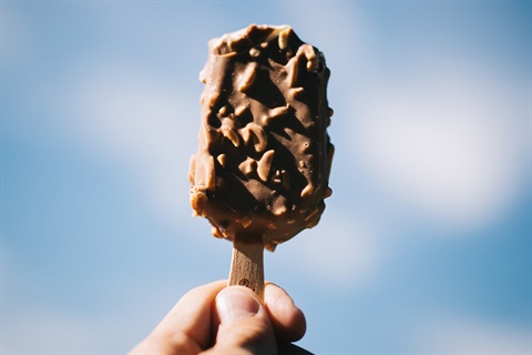 A closeup photo of a small magnum icecream in someone's hand.