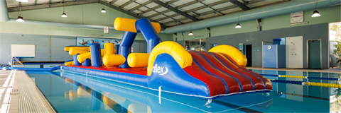 Poster: Inflatable obstacle course at Sussex Inlet Aquatic Centre
